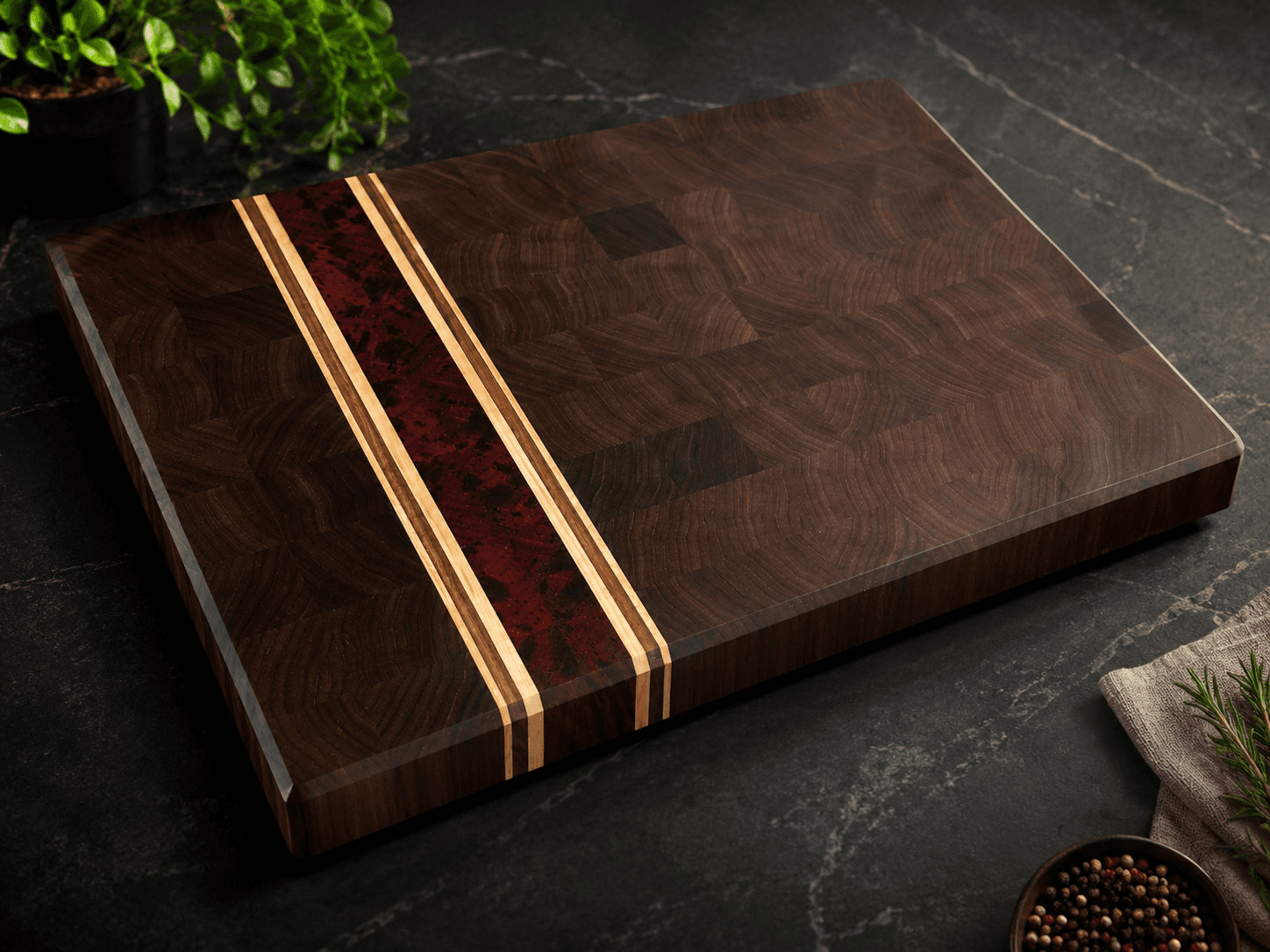 Handmade end-grain walnut cutting board with a red padauk stripe